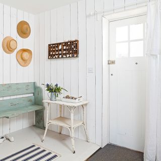 white room with wall hats and table