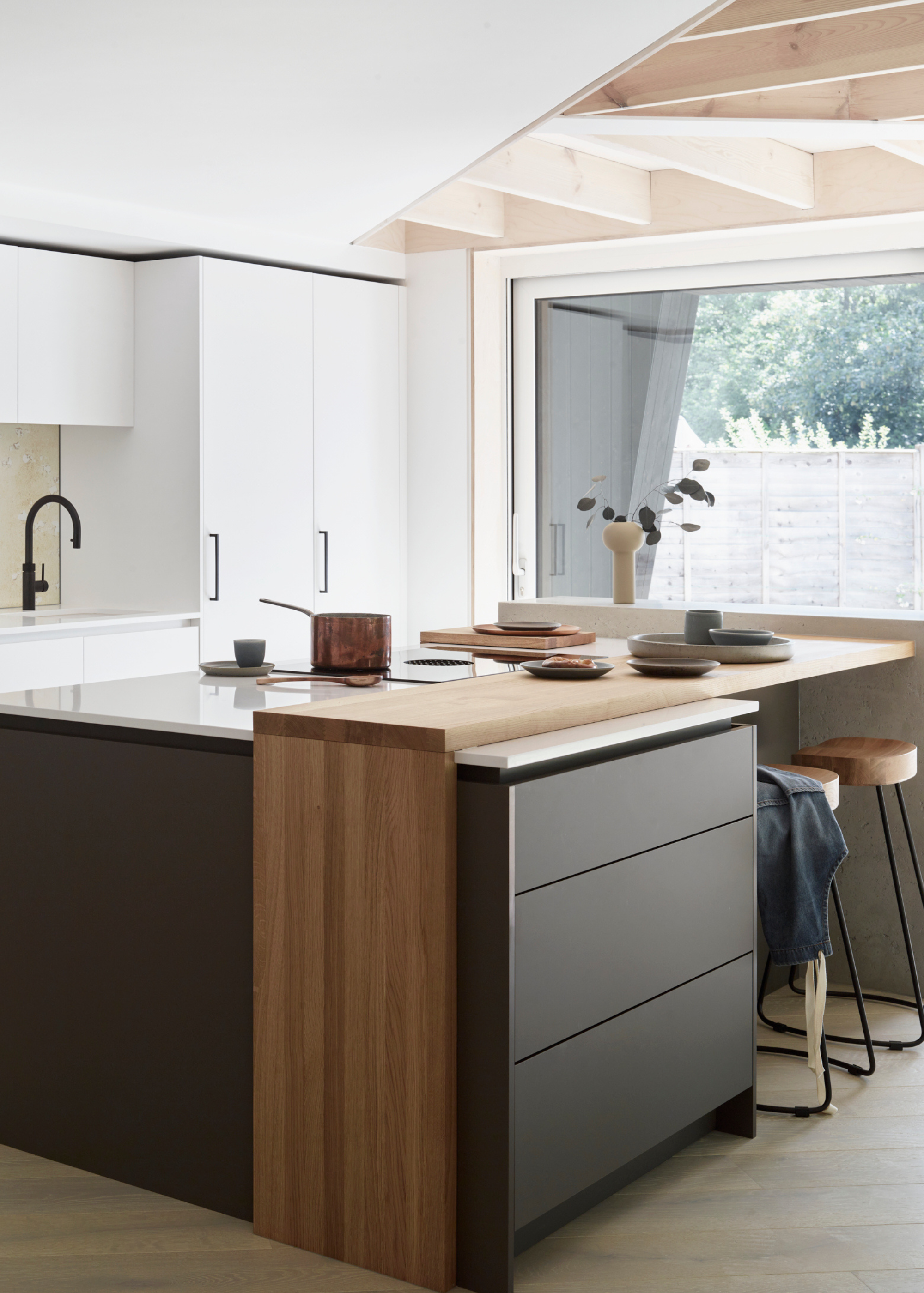 A modern scandi kitchen with black cabinetry and a wooden overlay