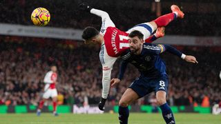 Bruno Fernandes of Manchester United and Gabriel Martinelli of Arsenal (airborne) during the Premier League match between Arsenal FC and Manchester United FC at Emirates Stadium on December 04, 2024 in London, England.