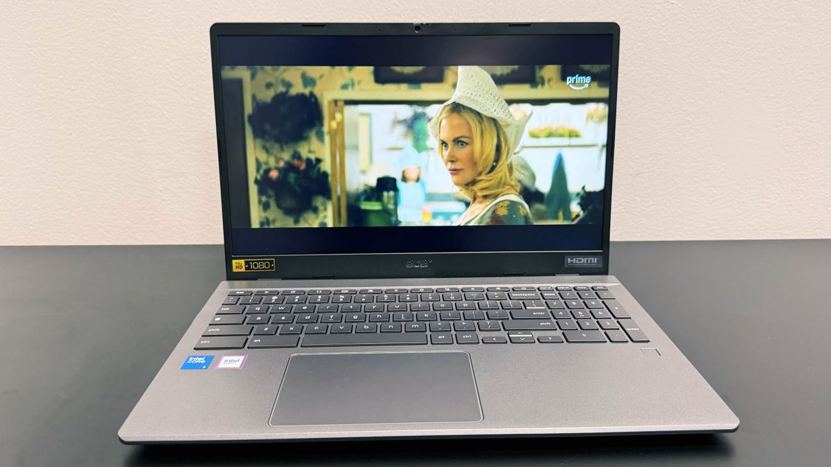 The Acer Chromebook Plus Enterprise 515 playing a movie trailer, on a black desk against a white background.