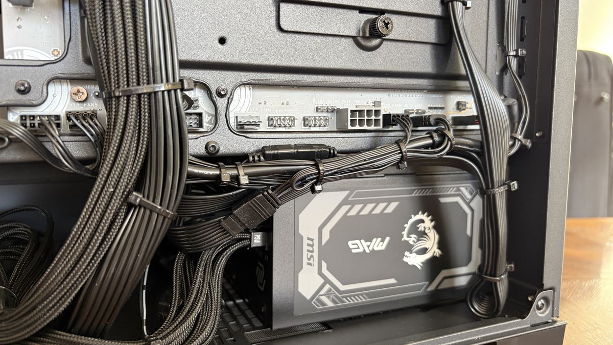 Inside an MG-1 MK.II computer case showing detailed cable management and connections to a PSU with a dragon logo. The setup is neat and organized.
