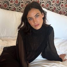 Alexa chung wears a long-sleeve black sheer dress.