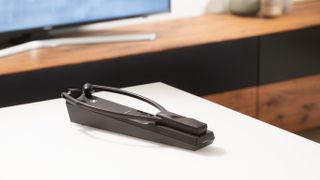 The RS 5200 headphones for TV sat on a desk in a living room