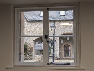 A DIY secondary glazing pane fixed over a window in a period building