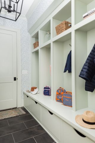 mudroom with white cabinetry and dark floor tile