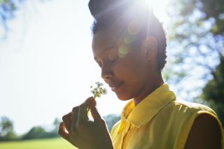 A woman smelling a flower