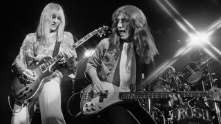 Alex Lifeson and Geddy Lee from Rush perform live on stage in Springfield, Massachusetts 9th December 1976. (Photo by Fin Costello/Redferns)