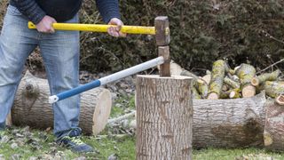 how to chop firewood: wedge and sledgehammer in wood