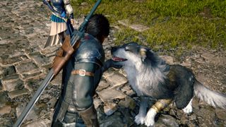 Clive pets Torgal the dog on a stone cobbled street in Final Fantasy 16