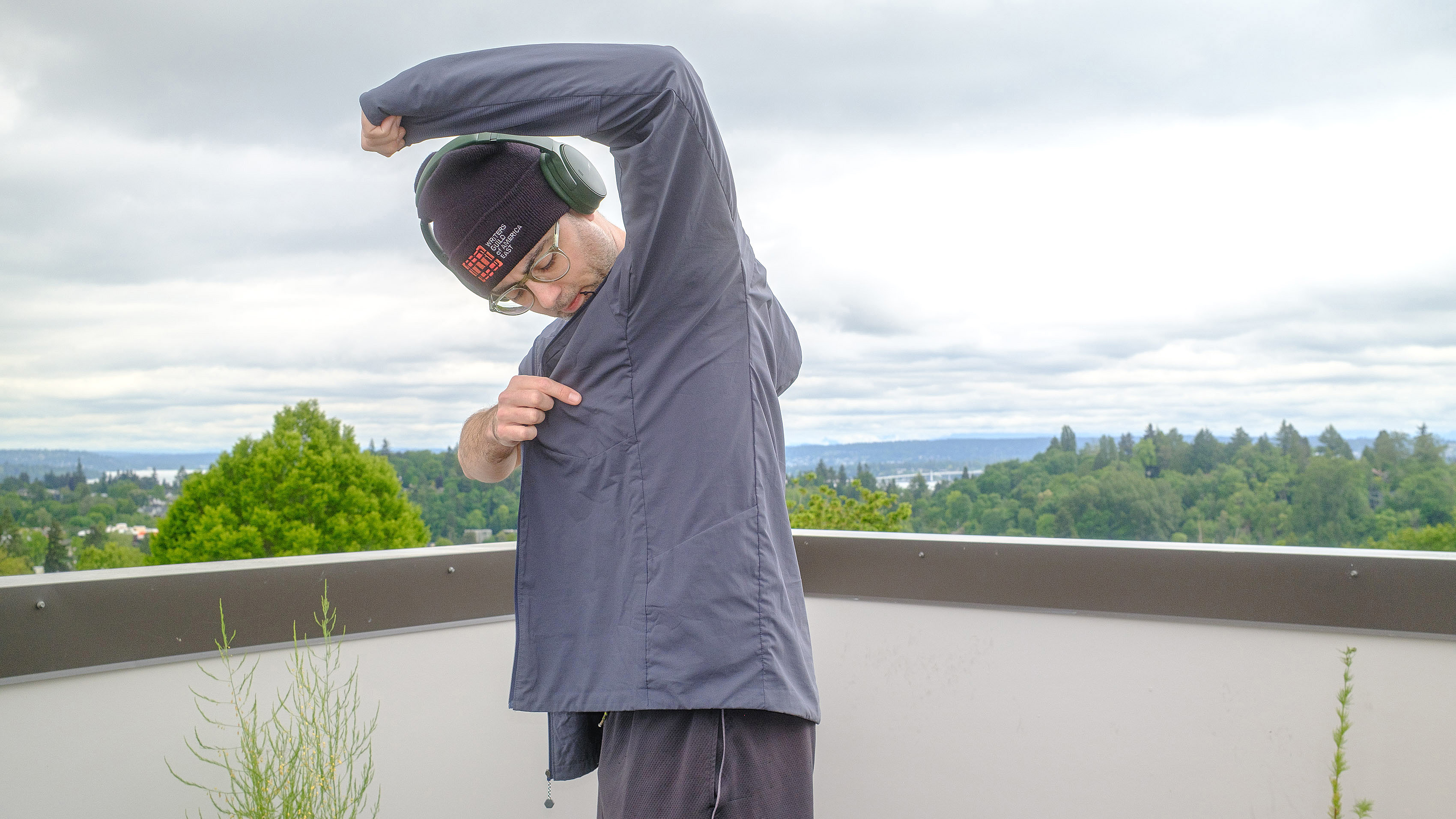 Senior writer Dan Bracaglia wearing the Patagonia Nano-Air Ultralight in grey/blue on the roof of his home in Seattle, Washington with trees and overcast skies in the distance