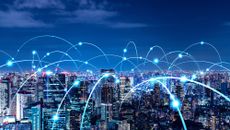 A cityscape at dusk with lines representing connectivity arching between buildings