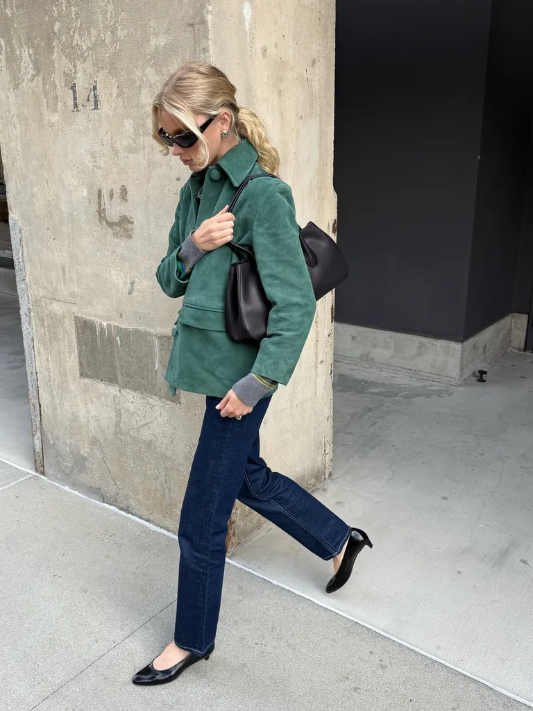 Woman in green jacket, jeans, and almond-toe pumps