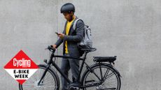 Male cyclist walking with his e-bike