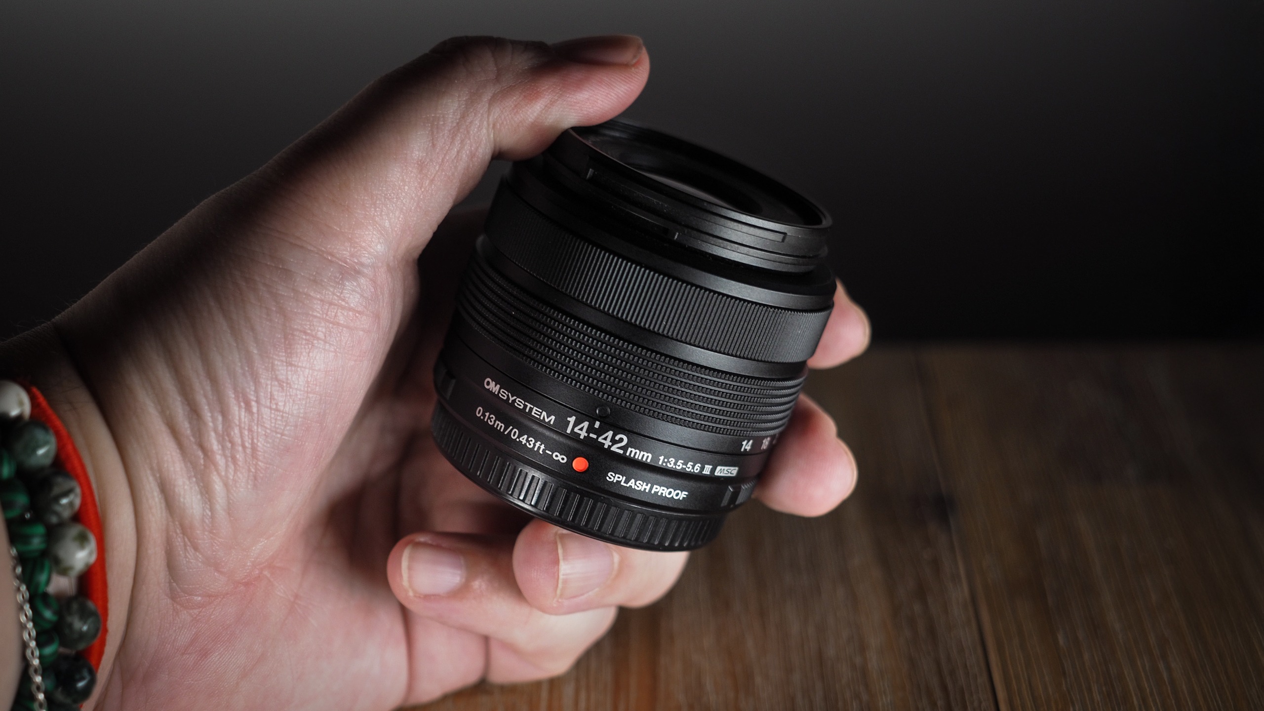 OM System M.Zuiko 14-42mm 3.5-5.6 III being held in hand
