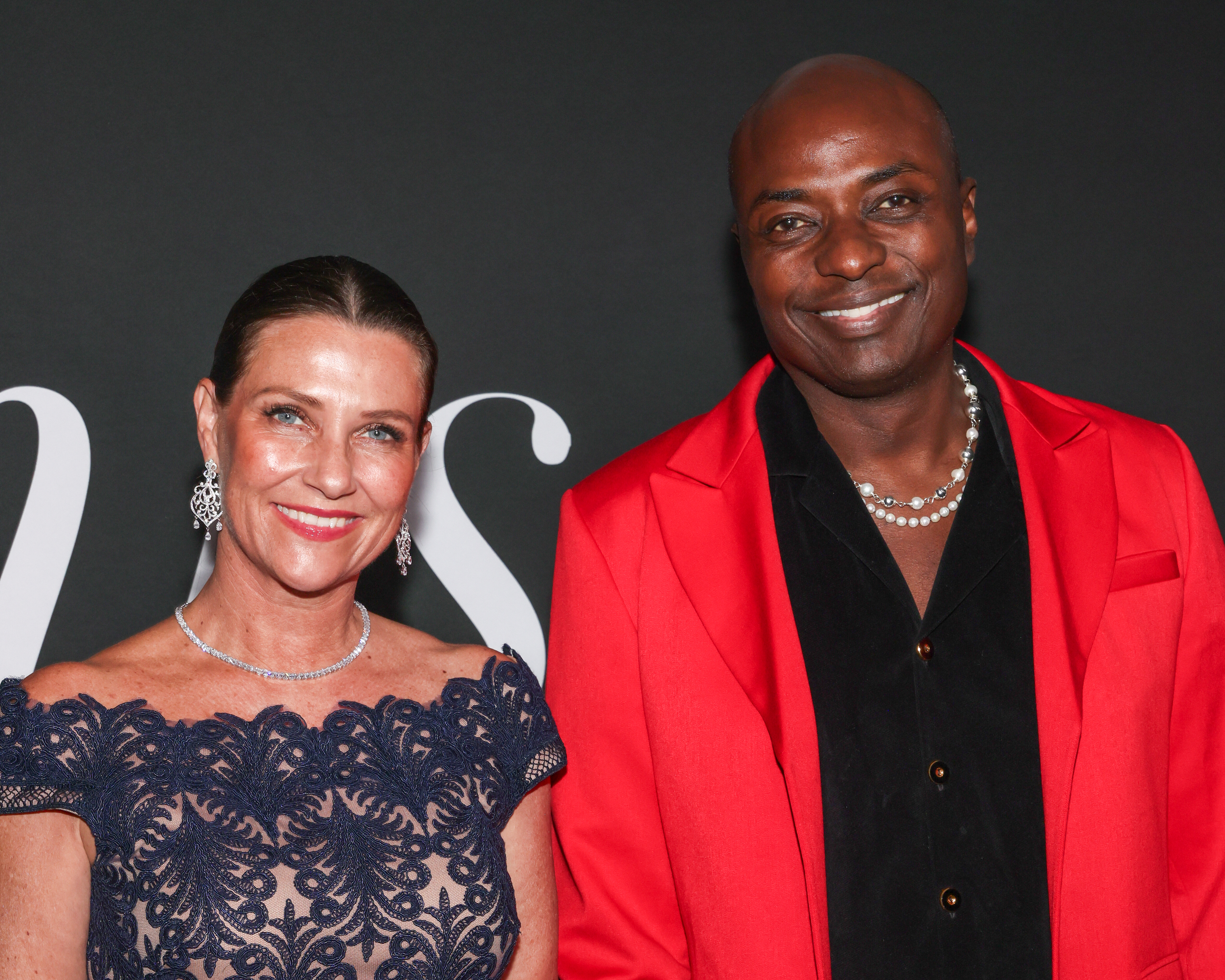 Princess Martha Louise wearing a blue lace dress and Shaman Durek Verrett in a red coat on the red carpet
