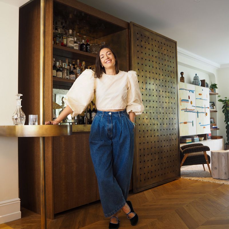 headshot of Alicia Meireles, standing in front of at-home bar