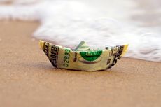 money boat on a sandy shore with ocean froth 