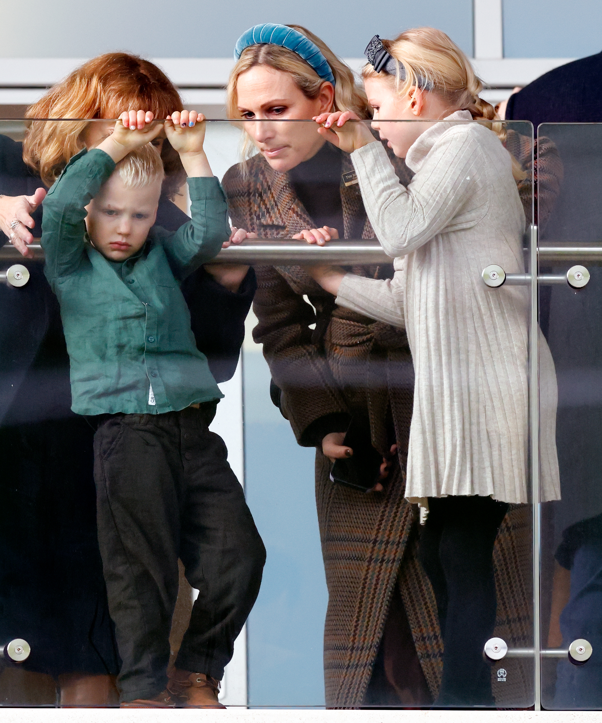 Lucas and Lena Tindall hanging on a balcony with Zara Tindall
