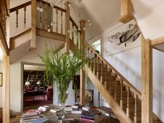 Fig 2: The new oak staircase in the dairy range, with the study—one wall covered with an adapted pedimented bookcase—glimpsed through the doorway on the ground floor. Boxes Farm, Northamptonshire. ©Paul Highnam for Country Life