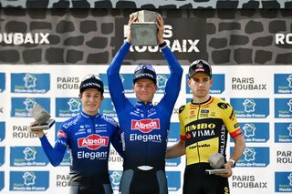 Paris-Roubaix winner Mathieu van der Poel hoists the cobblestone trophy 