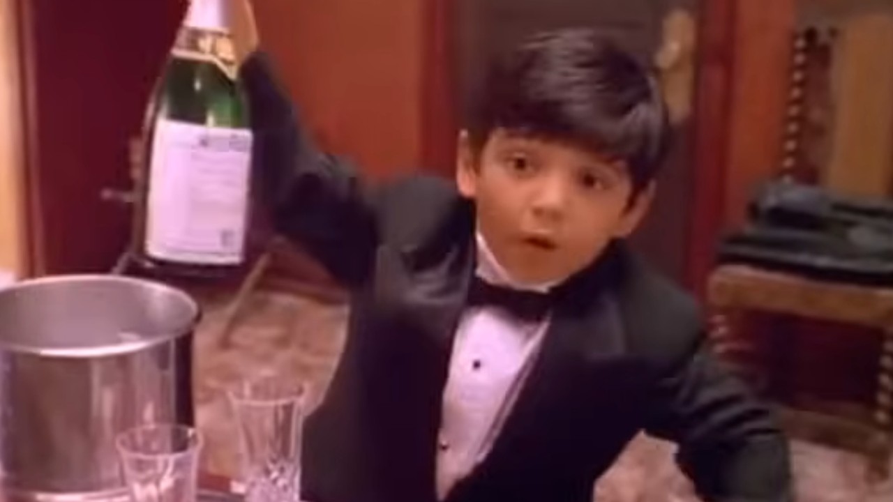 Danny Verduzco holding up a bottle in Four Rooms