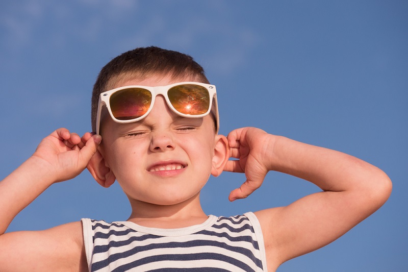 A boy squinting in the sun