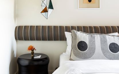 A bed headboard with bolster pillow