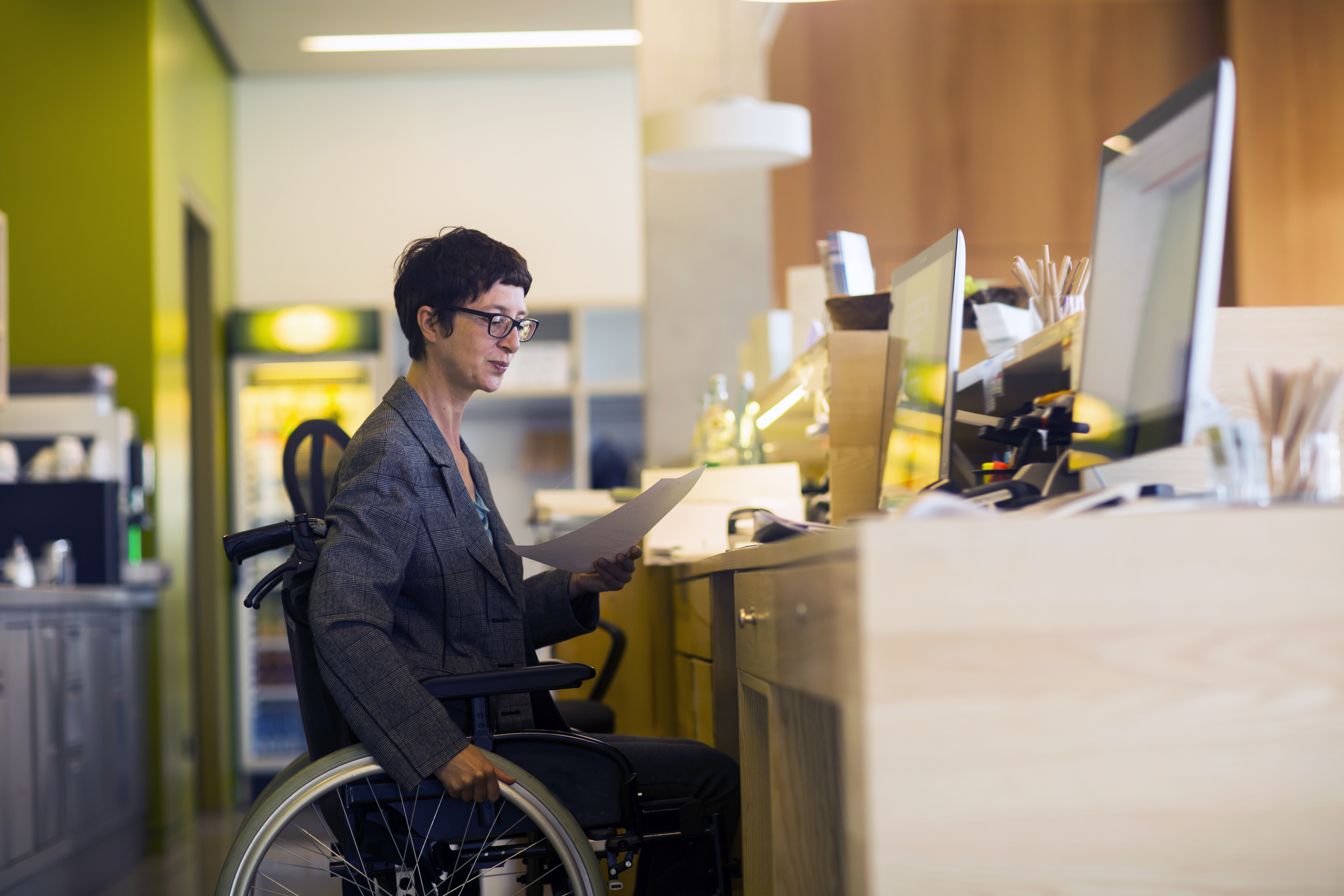 Woman in wheelchair sitting at a desk