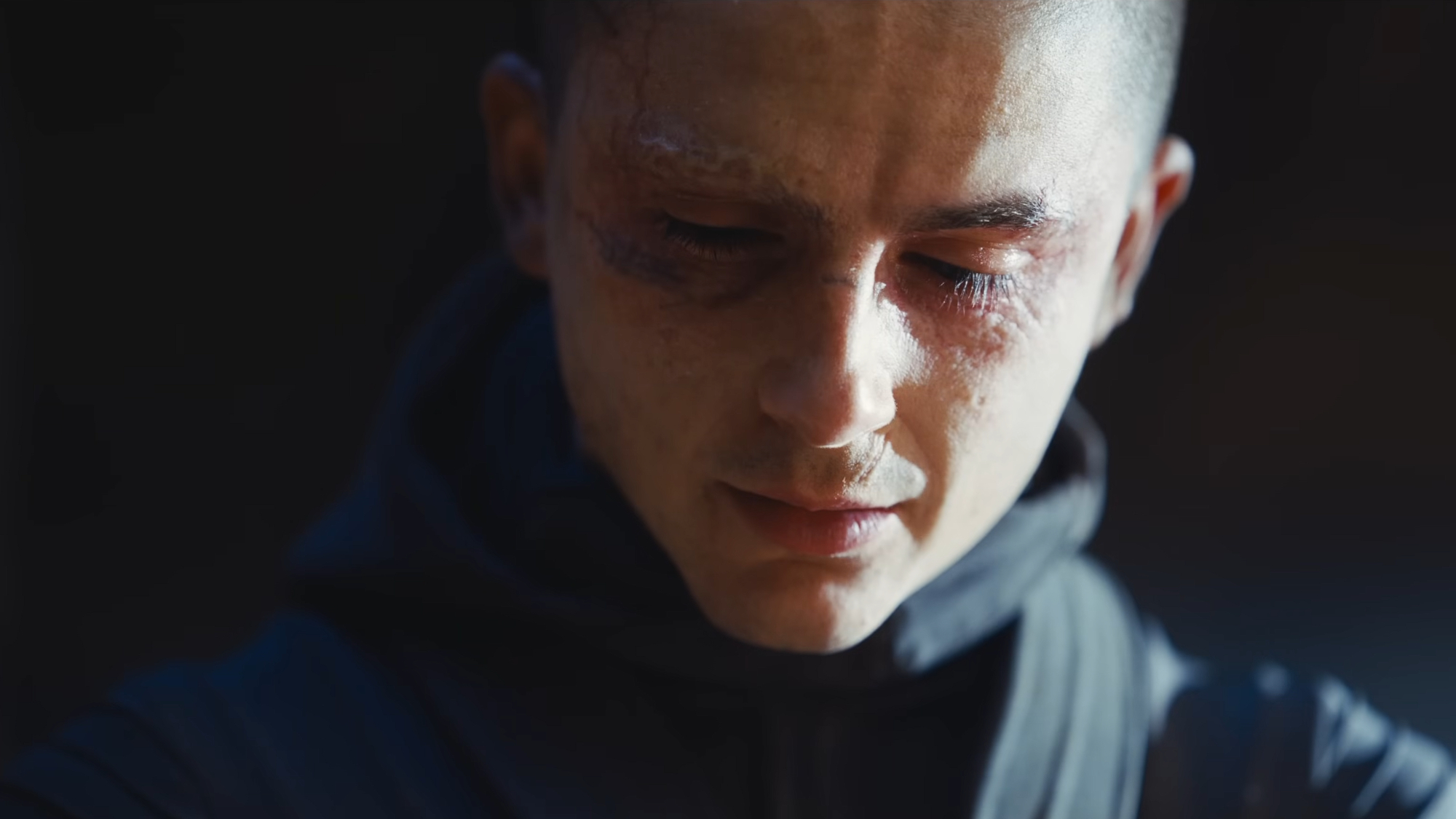 a man with a shaved head and burned eyes