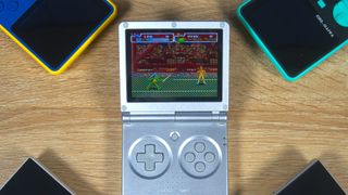 Anbernic RG35XXSP with Teenage Mutant Ninja Turtles: Turtles in Time on screen and two Super Pocket consoles at top corners and two Anbernic handhelds at bottom