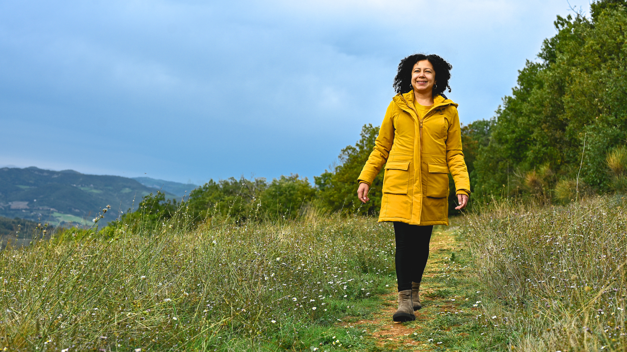 Woman walking along a track in a field
