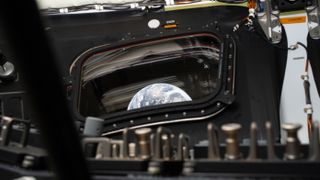Earth rises through the window from inside a spacecraft