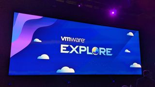 A conference screen bearing a cartoon background and the words VMWARE EXPLORE