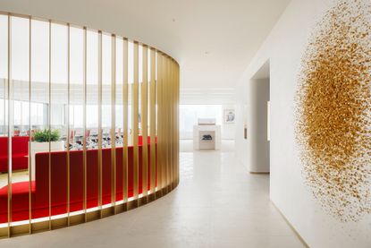 Cartier Japan HQ with white walls, gold circular enclosure and red seating area