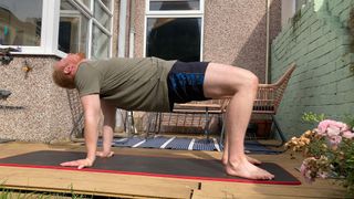 Fit&Well writer Harry Bullmore doing a tabletop stretch