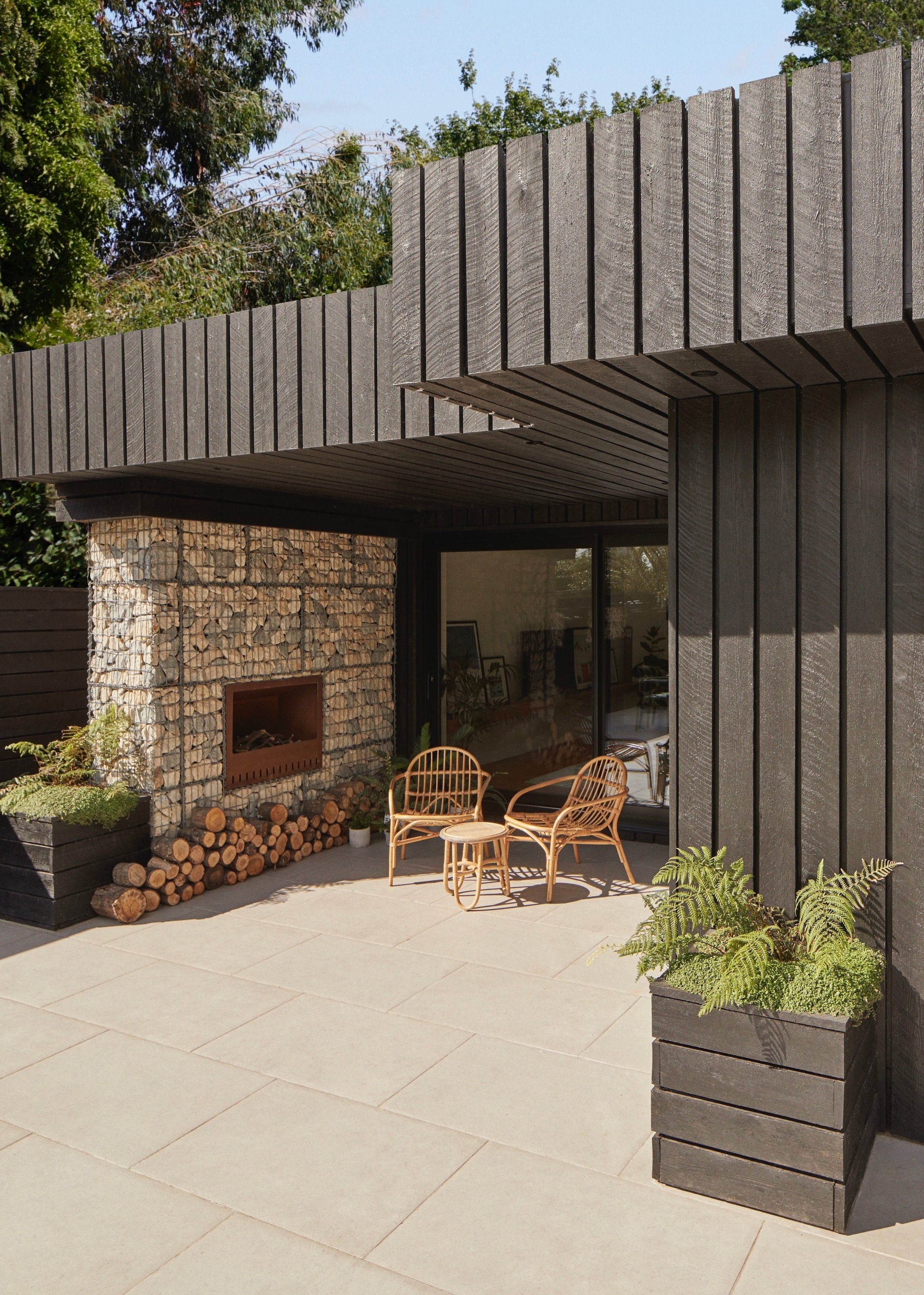 garden room with rattan table and chairs outside in a backyard of a home
