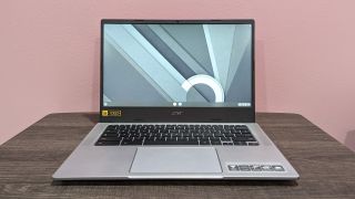  Acer Chromebook 514 on a wooden desk against a pink background