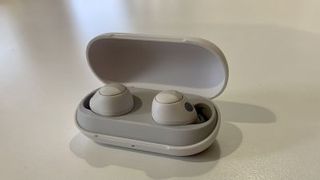 The Sony WF-C700N true wireless earbuds and their charging case on a grey background.
