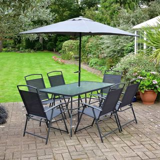 grey patio set with green lawn and potted plant