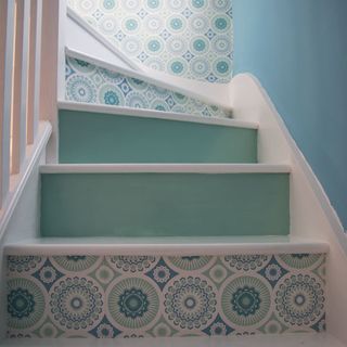 stairs with green textured wallpaper and blue wall