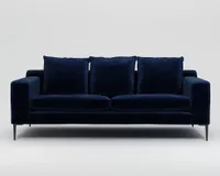A dark navy blue velvet sofa with high back cushions and high legs