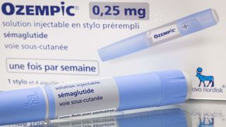 Syringe of Ozempic for weight loss in the forefront with the packaging in the background