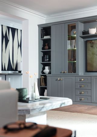 media room with custom cabinetry, TV, marble coffee table, artwork, ornaments