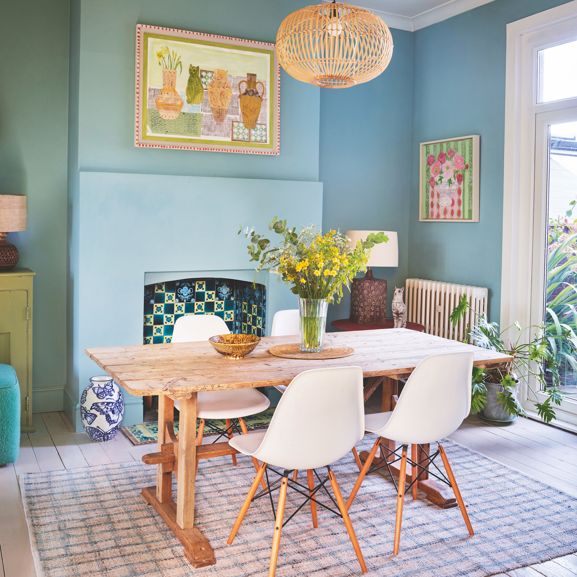 dining room painted in mid blue with wooden table and white eames style chairs