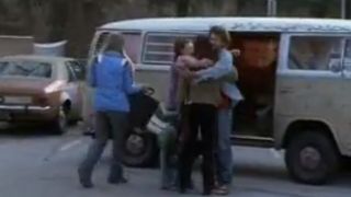 The cast of Freaks and Geeks hugging in front of a VW bus