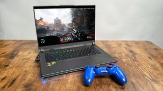 Asus ROG Strix G16 (G614FR) gaming laptop on a wooden desk against a gray background.