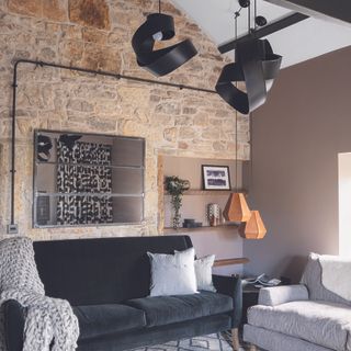 Living room with exposed brick wall, hanging lamp and ceiling pendant.