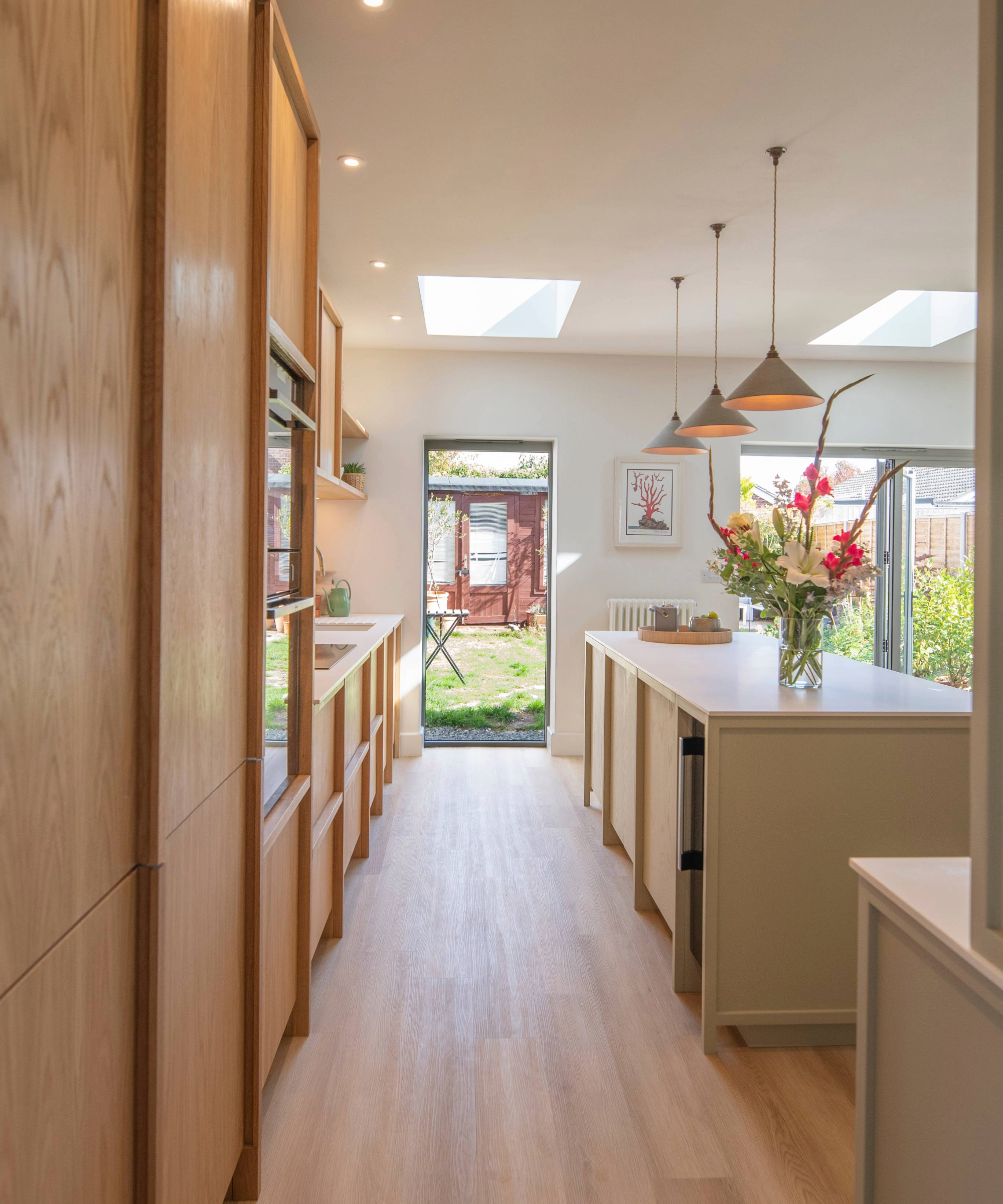 Galley kitchen idea with a mix of skylights, pendant light and spotlights