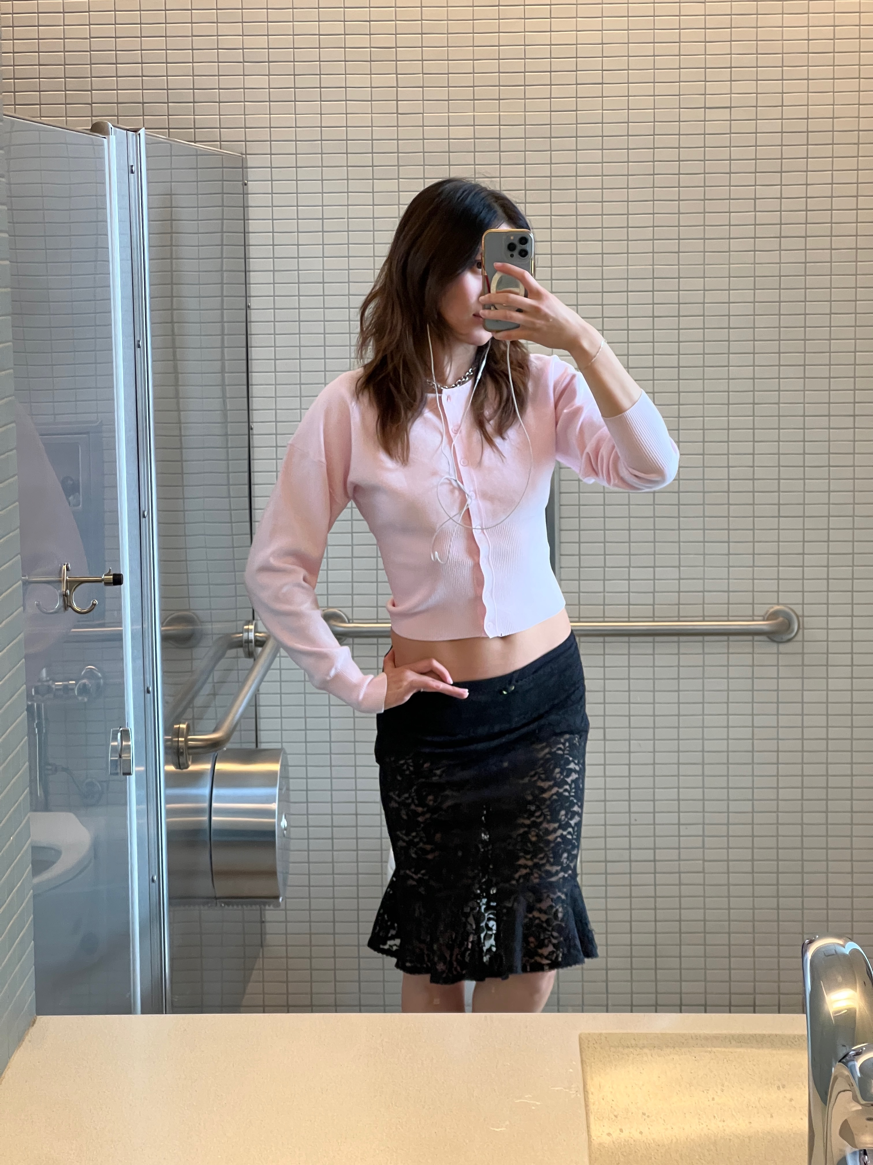 Vivian Li in a pink sweater and black lace skirt mirror selfie.