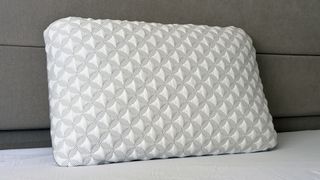 A close up of the Helix Talalay Latex pillow resting against the headboard in our reviewer's bedroom